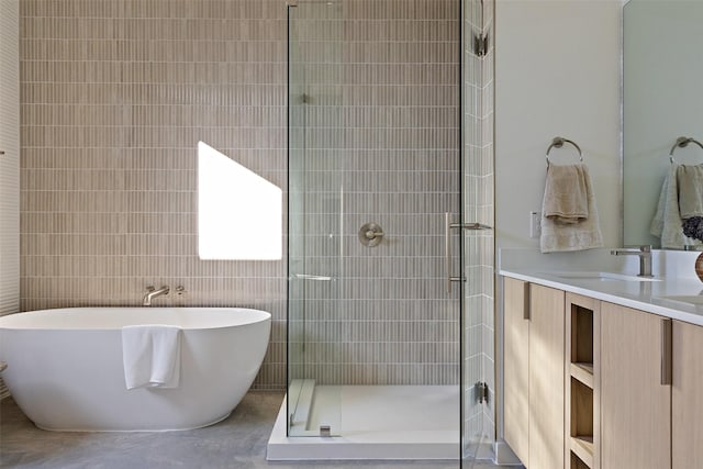 bathroom featuring tile walls, vanity, and independent shower and bath