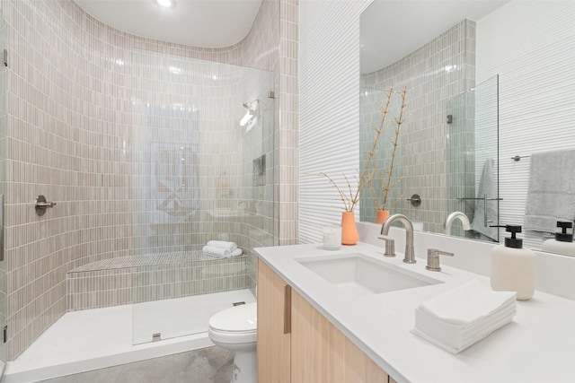 bathroom featuring toilet, a shower, and vanity