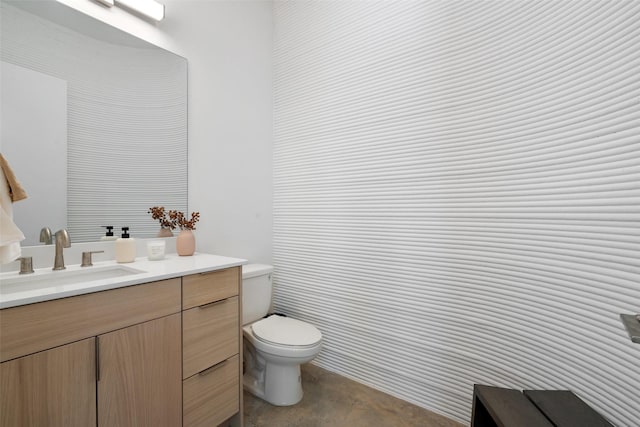 bathroom featuring toilet, concrete flooring, and vanity