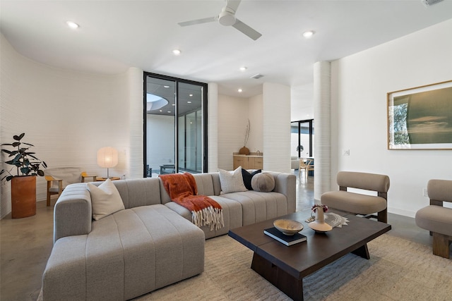 living room featuring ceiling fan and expansive windows