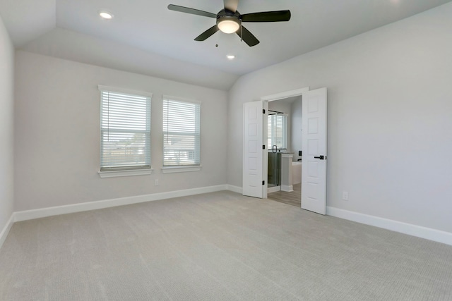 unfurnished bedroom featuring ceiling fan, light colored carpet, and vaulted ceiling