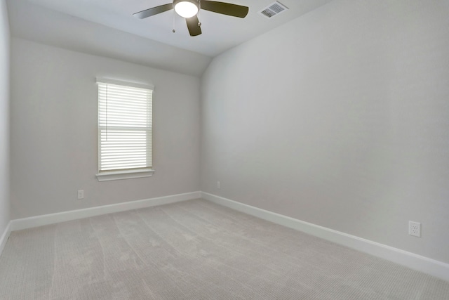 carpeted spare room featuring ceiling fan and vaulted ceiling