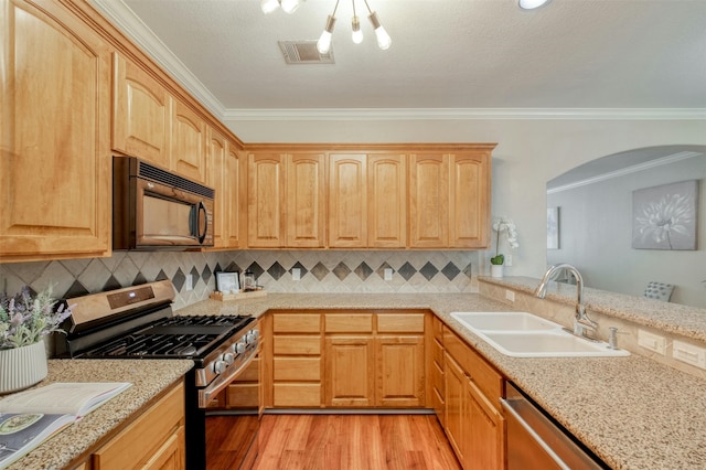 kitchen featuring decorative backsplash, sink, stainless steel appliances, and ornamental molding