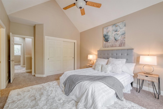 bedroom featuring a closet, light colored carpet, high vaulted ceiling, and ceiling fan