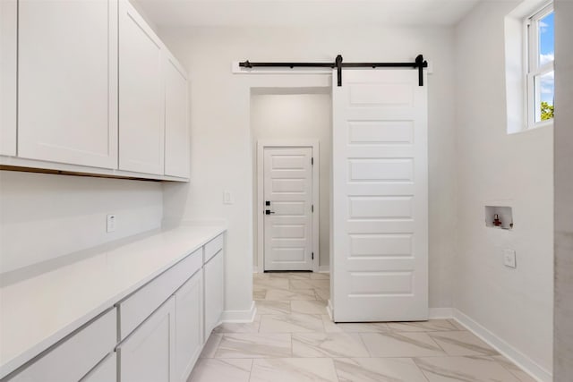 laundry area with washer hookup, cabinets, and a barn door