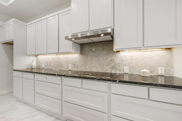 kitchen with black electric stovetop, decorative backsplash, white cabinets, and dark stone counters