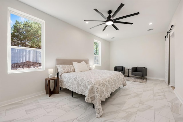 bedroom with ceiling fan and a barn door