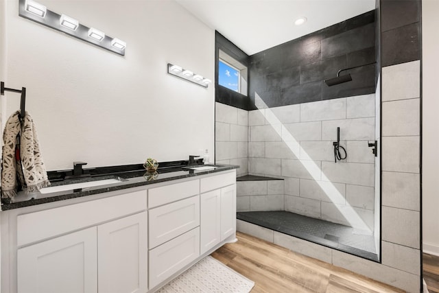 bathroom with vanity, hardwood / wood-style flooring, and tiled shower