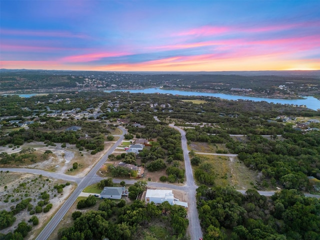 aerial view at dusk featuring a water view