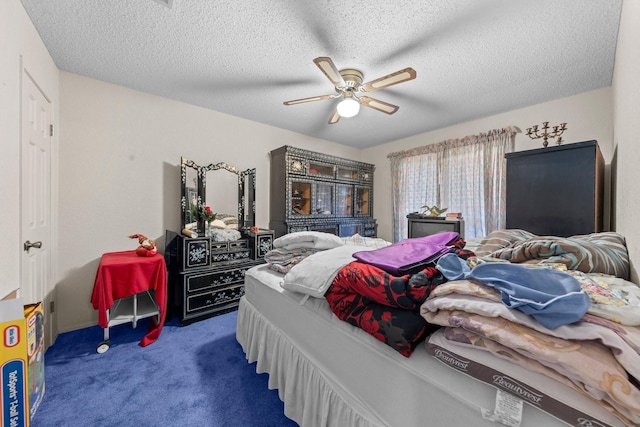 bedroom with ceiling fan, a textured ceiling, and carpet flooring