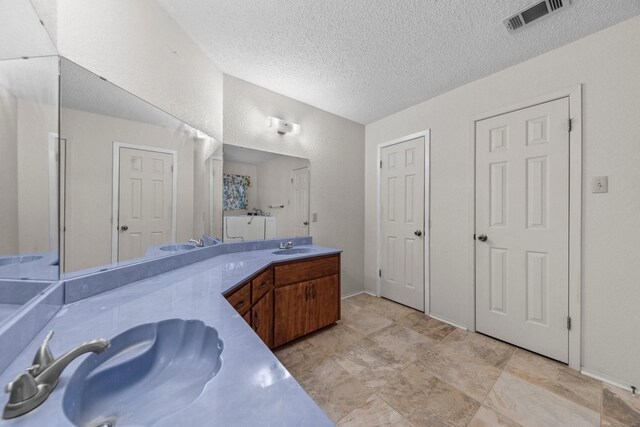 bathroom with a textured ceiling and vanity