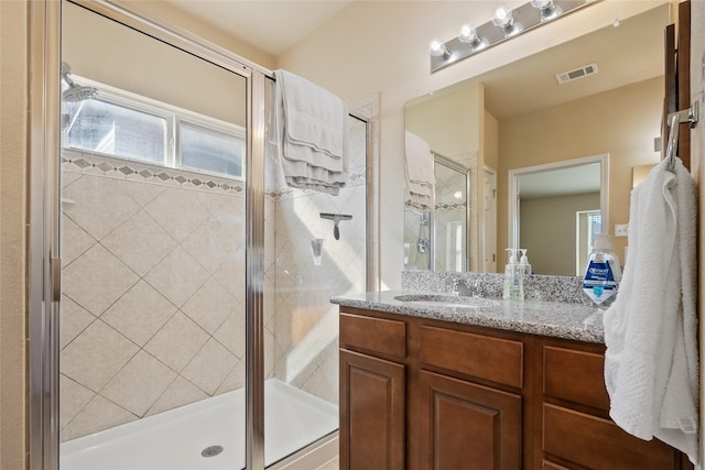 bathroom featuring vanity, plenty of natural light, and a shower with door