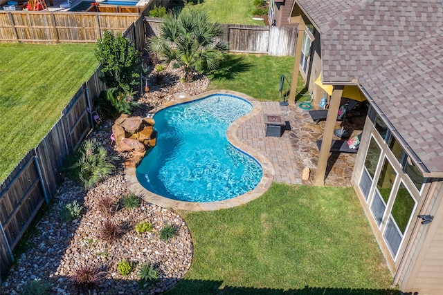 view of pool with a lawn and a patio