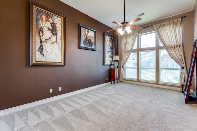 carpeted spare room featuring ceiling fan