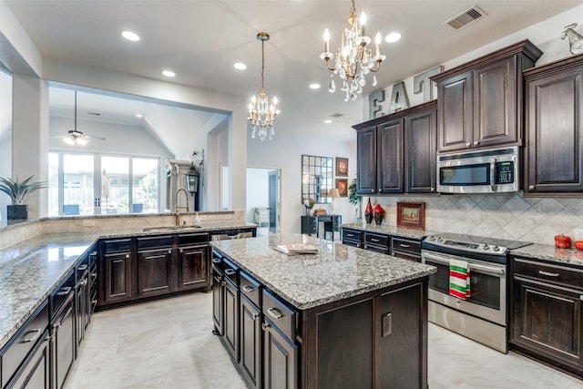 kitchen featuring dark brown cabinets, sink, stainless steel appliances, and a kitchen island