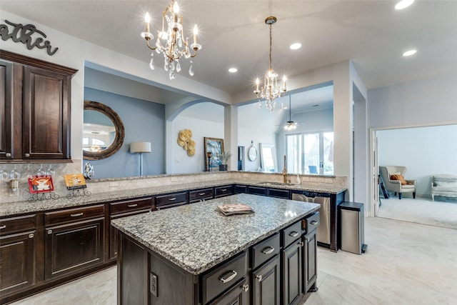 kitchen featuring tasteful backsplash, a center island, hanging light fixtures, dark brown cabinetry, and sink