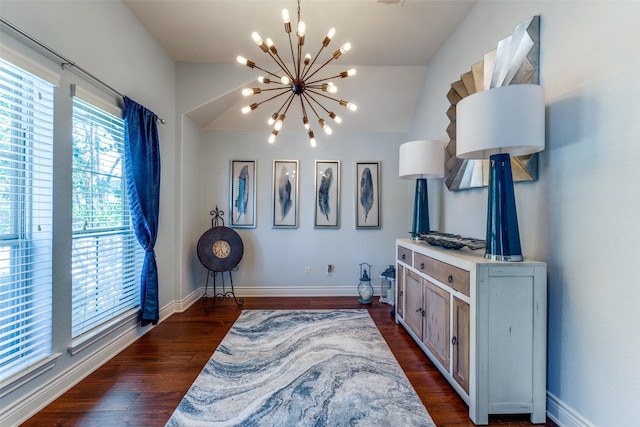 living area featuring vaulted ceiling, an inviting chandelier, and dark hardwood / wood-style floors