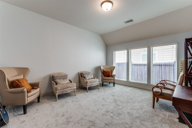 sitting room with light colored carpet and vaulted ceiling