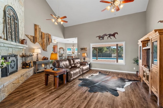1536 Kings Ranch Rd, Bandera, TX 78003 - living area with ceiling fan, high vaulted ceiling, wood finished floors, a stone fireplace, and baseboards