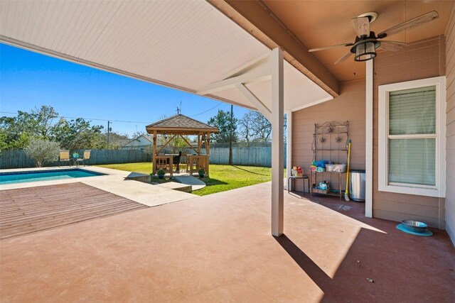 view of patio with a fenced in pool, a gazebo, and ceiling fan