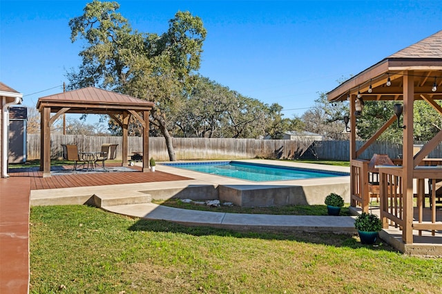 view of swimming pool featuring a wooden deck, a gazebo, and a lawn