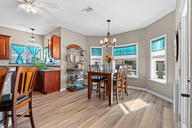 1536 Kings Ranch Rd, Bandera, TX 78003 - dining space featuring light wood-style flooring, plenty of natural light, a chandelier, and a ceiling fan