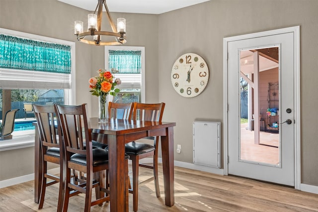 dining room featuring light hardwood / wood-style flooring, a notable chandelier, and plenty of natural light