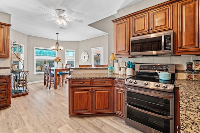 kitchen with stainless steel appliances, light hardwood / wood-style floors, and stone counters