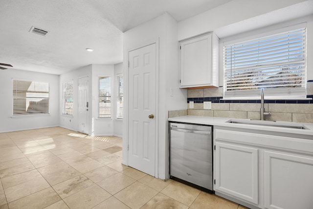 kitchen with dishwasher, white cabinetry, decorative backsplash, sink, and light tile patterned floors