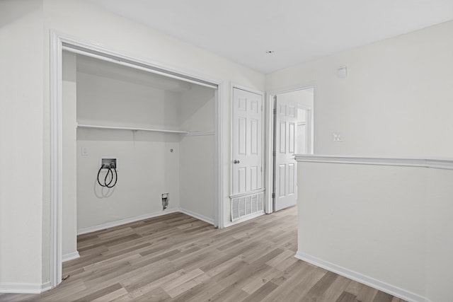 clothes washing area featuring washer hookup, electric dryer hookup, and light hardwood / wood-style flooring