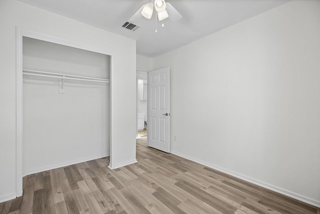 unfurnished bedroom featuring ceiling fan, a closet, and light wood-type flooring