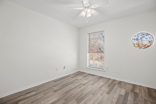 empty room featuring ceiling fan, a textured ceiling, and light wood-type flooring