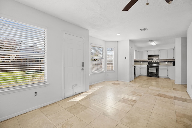 kitchen with decorative backsplash, plenty of natural light, electric range, and ceiling fan