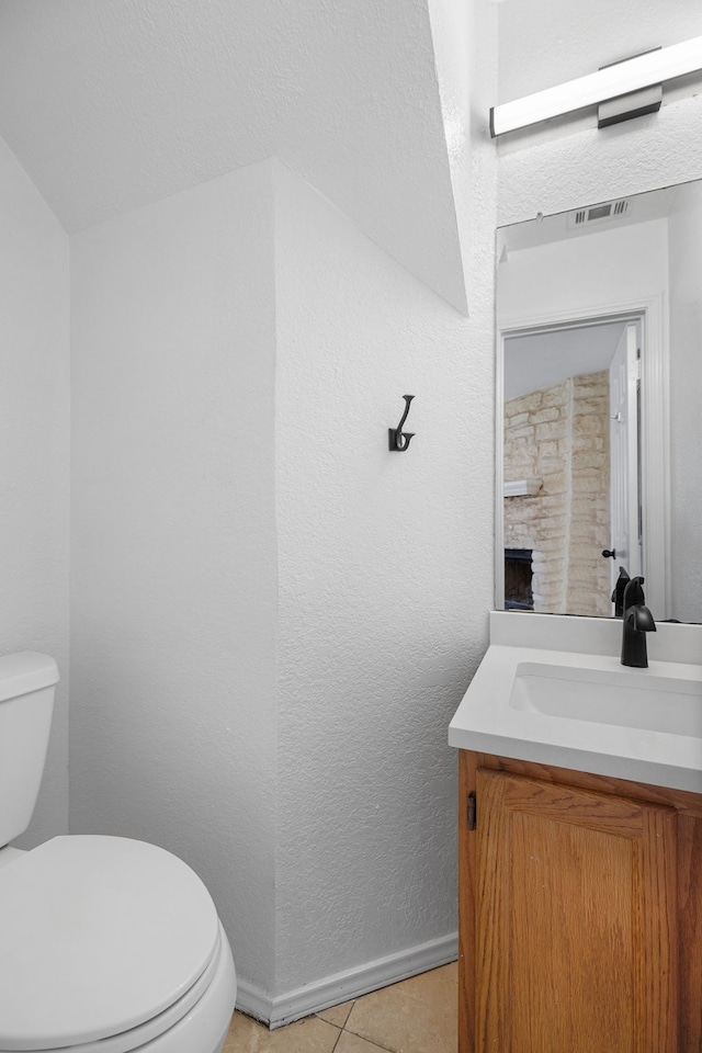 bathroom featuring toilet, vanity, and tile patterned flooring