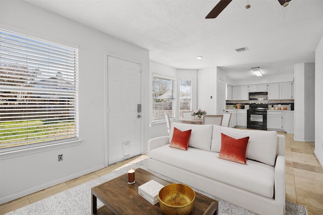 tiled living room with ceiling fan