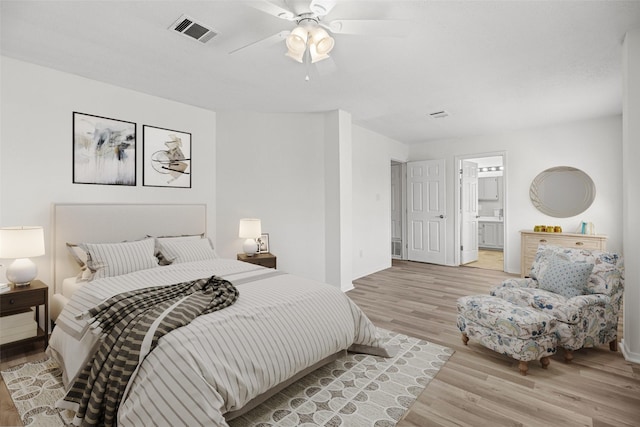 bedroom with ceiling fan, light hardwood / wood-style floors, and connected bathroom