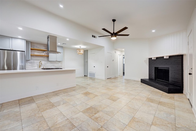 unfurnished living room featuring ceiling fan, sink, and a fireplace