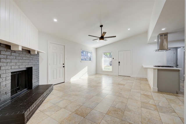 unfurnished living room featuring a brick fireplace, ceiling fan, and vaulted ceiling