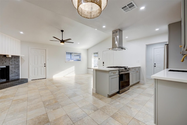 kitchen with lofted ceiling, stainless steel appliances, sink, gray cabinets, and island range hood