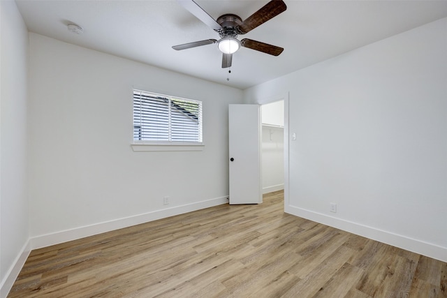 spare room with ceiling fan and light wood-type flooring