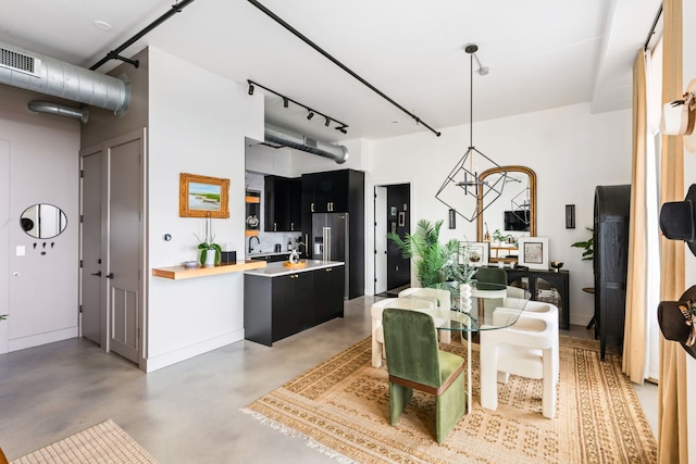 kitchen featuring concrete flooring, butcher block countertops, and decorative light fixtures