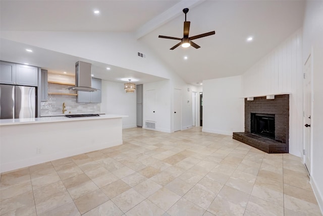 unfurnished living room featuring ceiling fan, a fireplace, beamed ceiling, and high vaulted ceiling