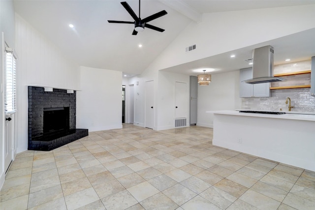 unfurnished living room with ceiling fan, a fireplace, high vaulted ceiling, beam ceiling, and sink