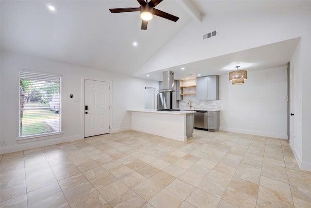 kitchen with beamed ceiling, kitchen peninsula, island range hood, stainless steel dishwasher, and gray cabinetry