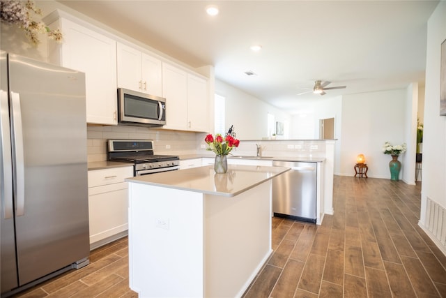 kitchen featuring stainless steel appliances, white cabinetry, and a kitchen island