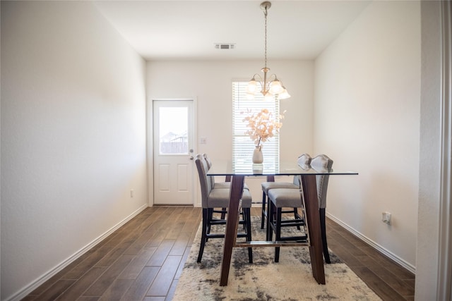 dining area featuring visible vents, baseboards, a notable chandelier, and dark wood-style floors