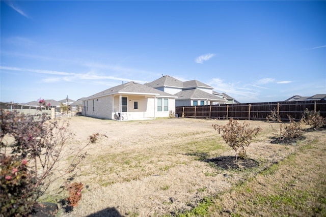 rear view of house with a fenced backyard