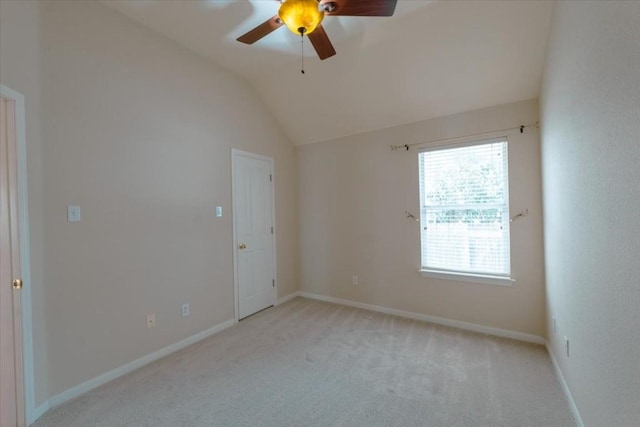 carpeted empty room with vaulted ceiling and ceiling fan