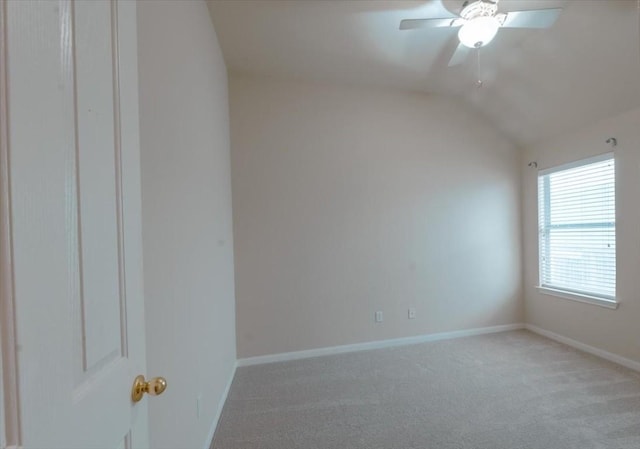 carpeted spare room featuring ceiling fan and vaulted ceiling