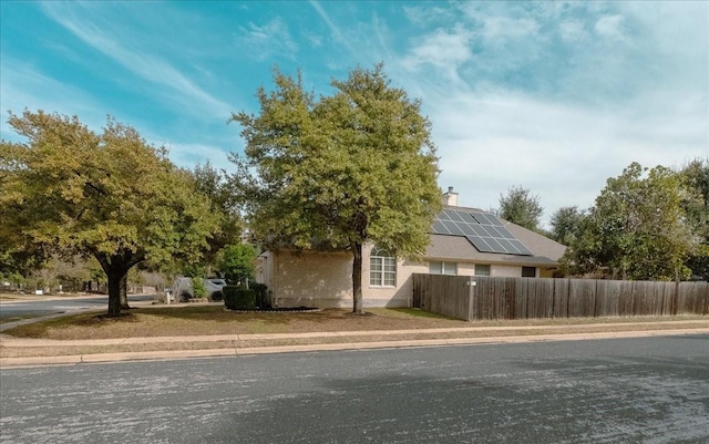 view of side of property featuring solar panels